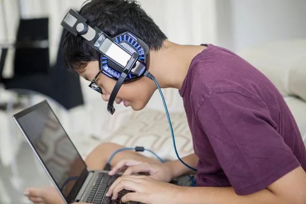 Asijská mládež s laptopem a sluchátky — Stock fotografie