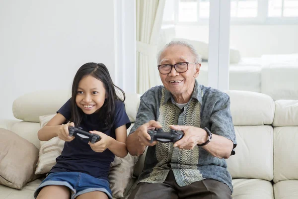 Chica alegre y abuelo jugando videojuegos —  Fotos de Stock