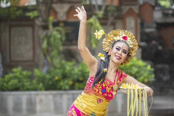 Schöne balinesische Tänzerin wirft Frangipani-Blumen — Stockfoto