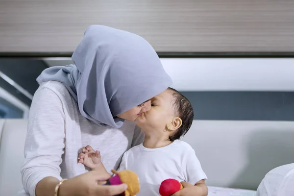 Bebê menina beijando sua mãe no quarto — Fotografia de Stock