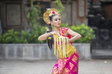 Bali dansçı çiçek yaprakları bir kase ile dans