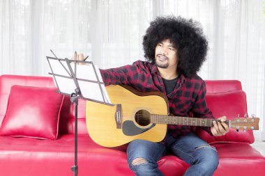 Gitar çalarken şarkı yazan müzisyen