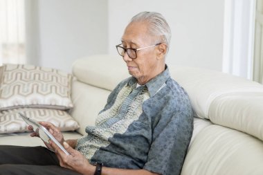 Kıdemli adam ve kızı akıllı telefonda müzik keyfini çıkarın