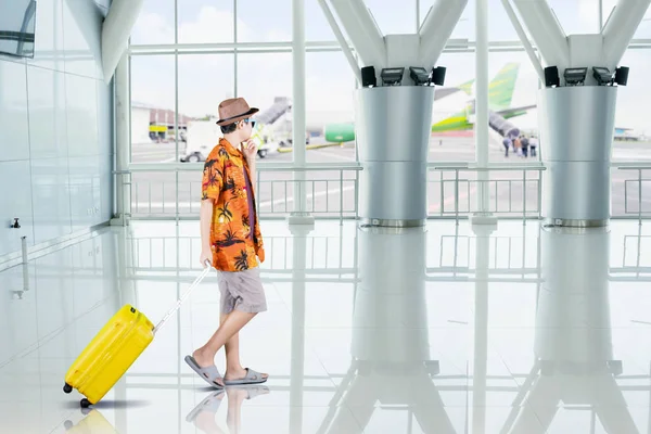 Preteen chłopiec przewozi bagaż w terminalu lotniska — Zdjęcie stockowe