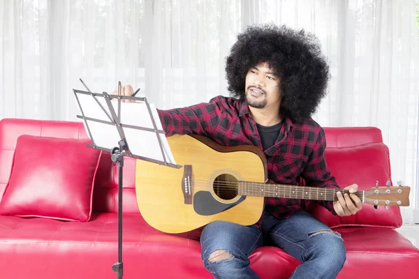 Gitar çalarken şarkı yazan müzisyen