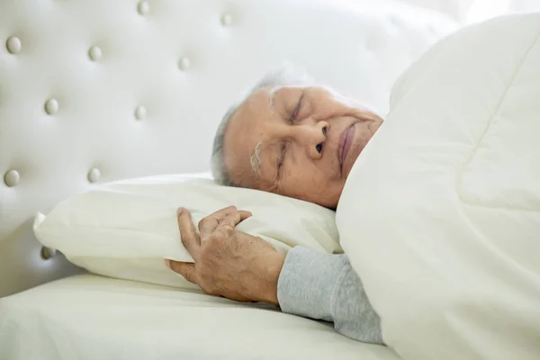 Starší muž spí dobře na posteli — Stock fotografie