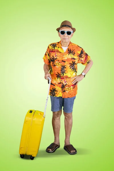 Anciano sosteniendo un equipaje en el estudio — Foto de Stock