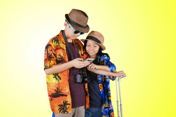 Två barn turister som använder en telefon på Studio — Stockfoto