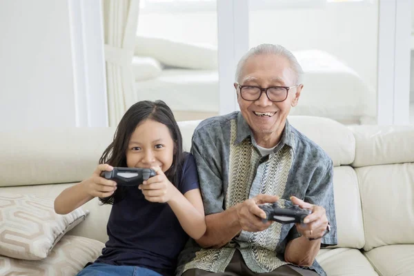 Senior homme et petite-fille jouer à des jeux vidéo — Photo