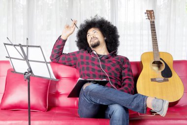 Müzisyen evde bir şarkı bestelemek için düşünüyor