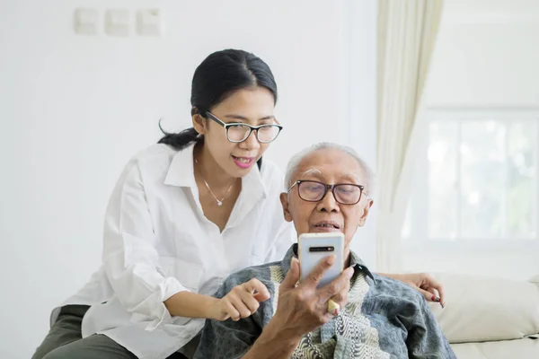 그의 딸과 함께 전화를 사용하는 노인 — 스톡 사진