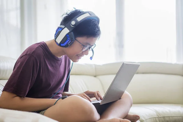 Unbekannter preußischer Junge sieht Fernseher mit Kopfhörer — Stockfoto