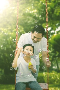 Parkta babasıyla oynayan küçük çocuk