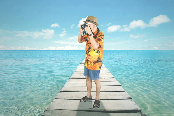 Homem velho feliz usando óculos de sol no estúdio — Fotografia de Stock