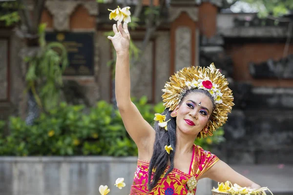 Female Pendet dancer throwing frangipani flower — Stock Photo, Image