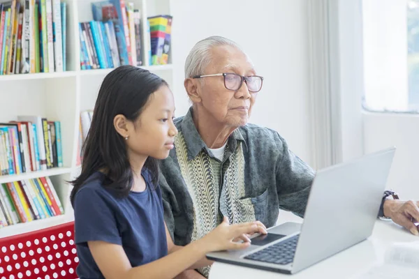 소녀는 할아버지와 노트북 컴퓨터를 사용 — 스톡 사진