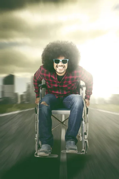 Hombre feliz sentado en silla de ruedas con movimiento rápido — Foto de Stock