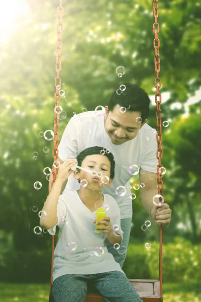 Criança brincando com seu pai no parque — Fotografia de Stock