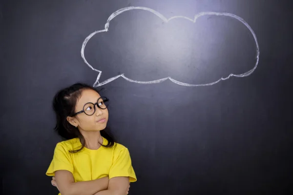 Confused little girl standing with question marks — Stock Photo, Image