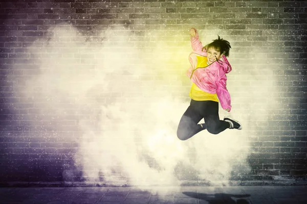 Cheerful hip-hop dancer jumping with smoke — Stock Photo, Image