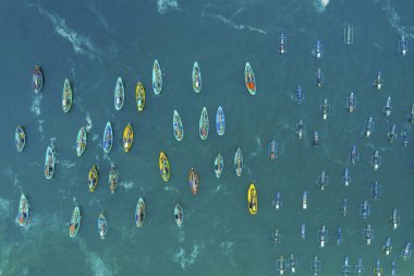 Crowded fishing boats sailing on Papuma beach clipart