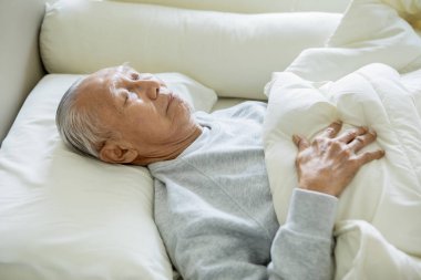 Evde dizüstü bilgisayar kullanan yaşlı bir adam