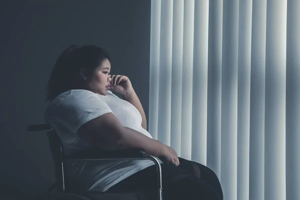 Mulher gorda deficiente chorando perto da janela — Fotografia de Stock