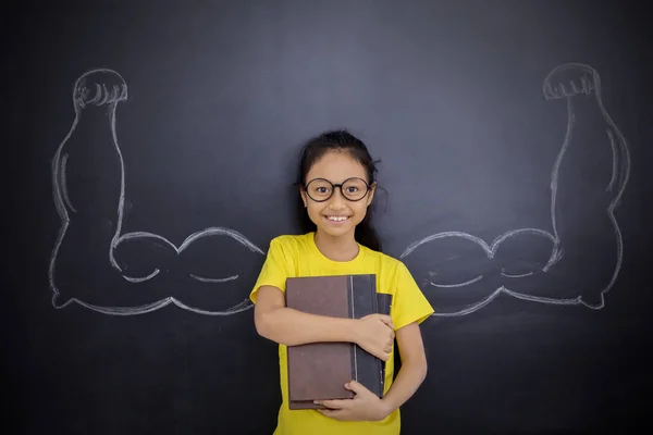 Felice bambina mostrando i suoi bicipiti — Foto Stock