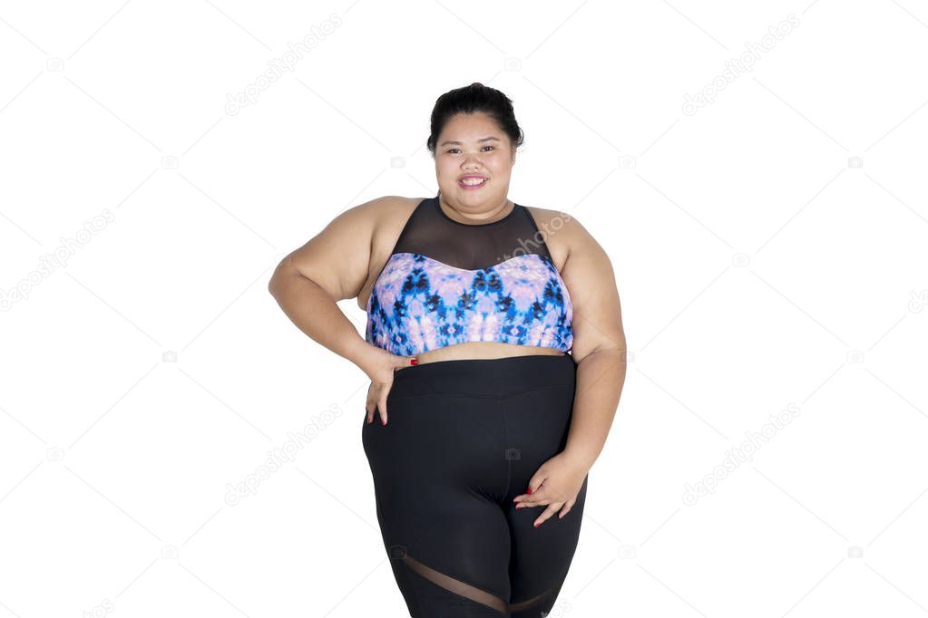 Confident fat woman wearing sportswear on studio