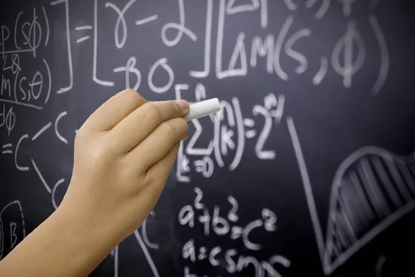 Bambina mano scrive formula matematica — Foto Stock