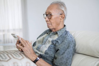 Kütüphanede tablet kullanan kıdemli adam