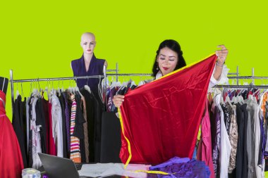 Güzel tasarımcı stüdyoda bir kumaş ölçme