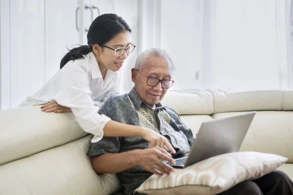 Velho aprendendo a usar um laptop com sua filha — Fotografia de Stock