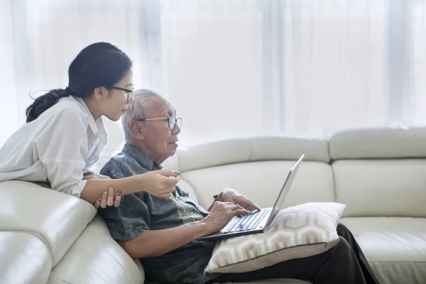 Homme âgé utilisant une tablette dans la bibliothèque — Photo