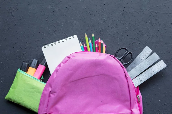 Rosa Rucksack mit verschiedenen Schulmaterialien — Stockfoto