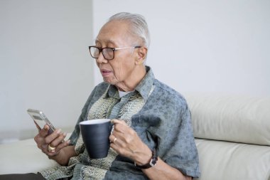 Kütüphanede tablet kullanan kıdemli adam