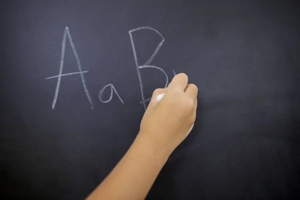 Рука школьницы пишет буквы алфавита — стоковое фото