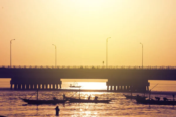 Silhouette di pesca dei pescatori vicino al ponte Suramadu — Foto Stock