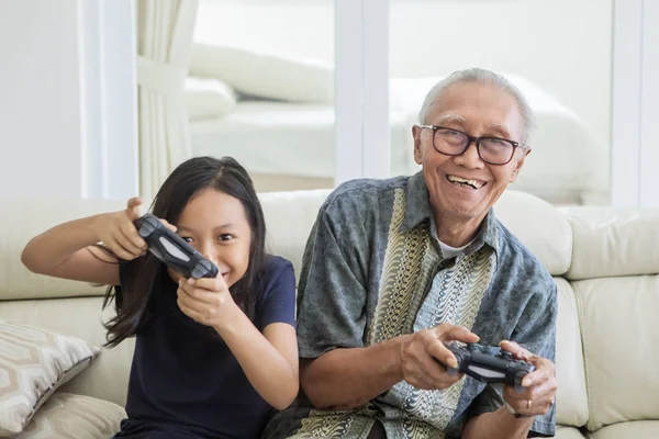 Niño alegre jugando videojuegos con el abuelo —  Fotos de Stock