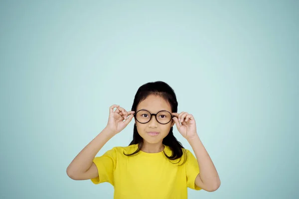 Confident little girl wearing eyeglasses on studio — Stock Photo, Image