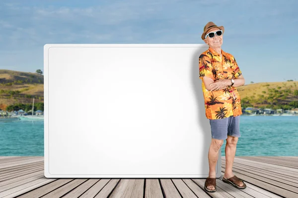 Confident old tourist leaning on a blank whiteboard — Stock Photo, Image