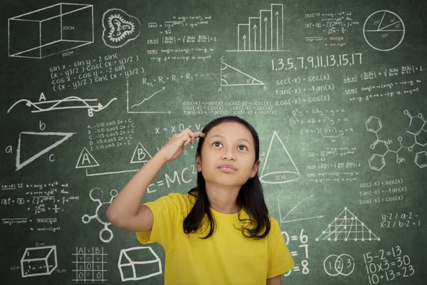 Ragazza premurosa che guarda scarabocchi in una classe — Foto Stock