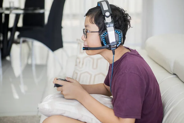 Мальчик-подросток играет в видеоигры с джойстиком — стоковое фото