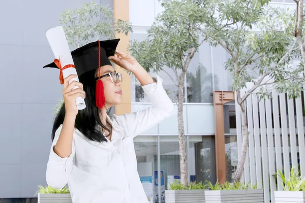 Jovem mulher usando um boné de formatura — Fotografia de Stock