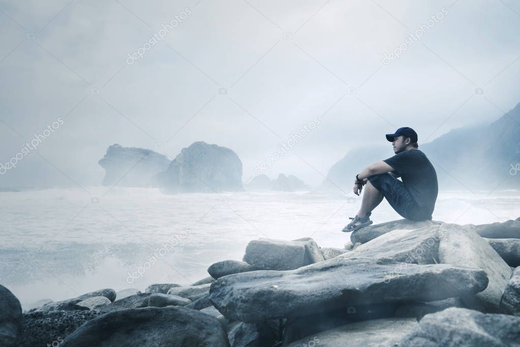 Young man enjoying a foggy Papuma beach view
