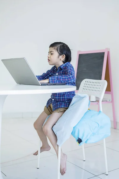 Злой маленький мальчик с ноутбуком — стоковое фото