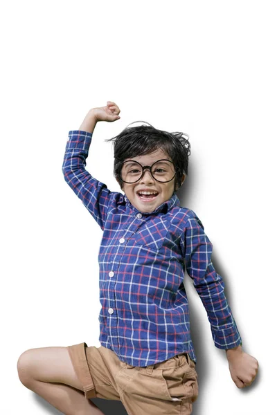 Menino alegre pulando no estúdio — Fotografia de Stock