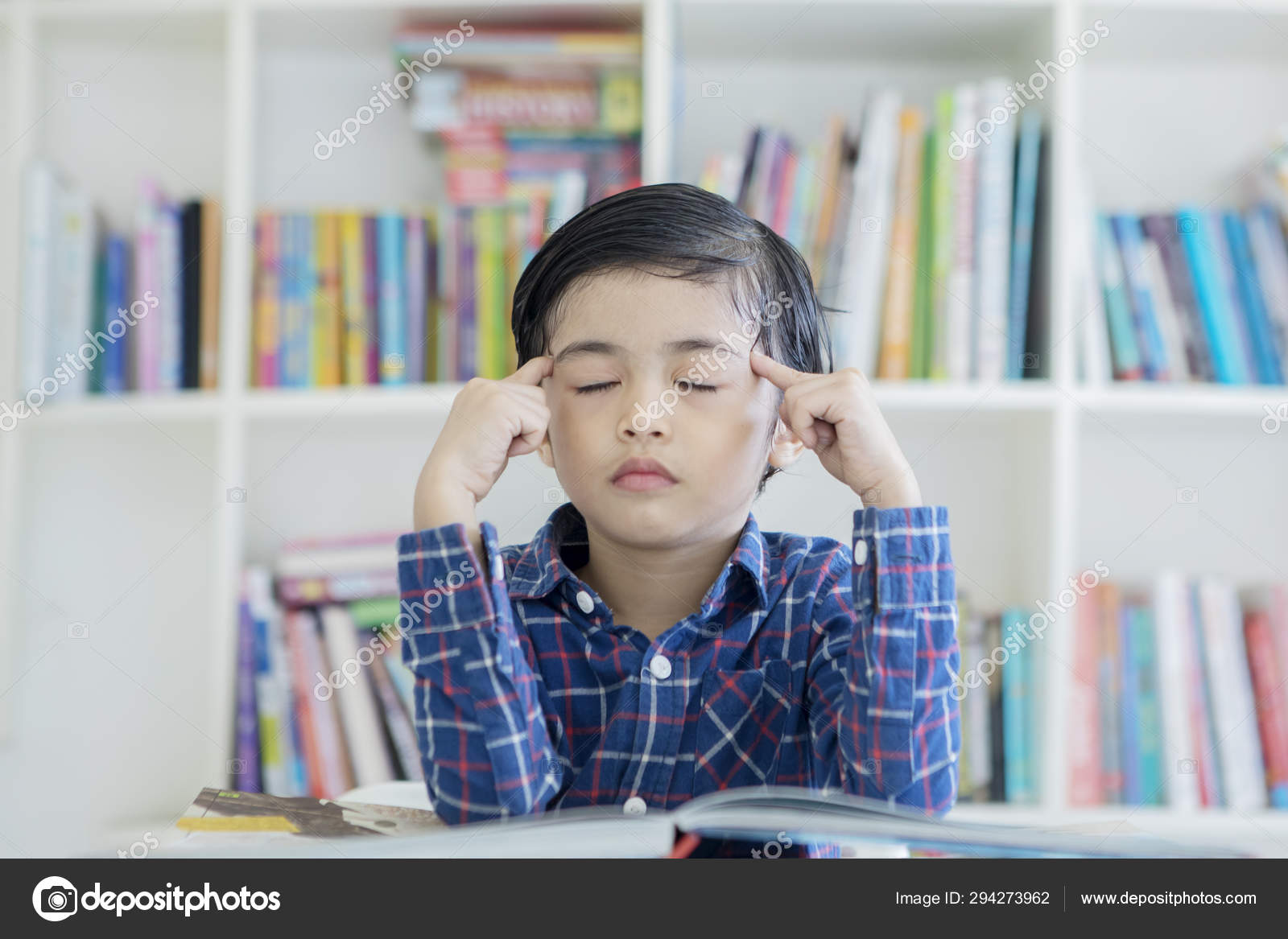 Menino pensando com os olhos fechados na biblioteca — Foto © realinemedia  #294273962, image size:1600x1167