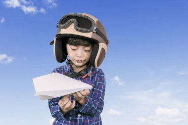 Küçük pilot açık havada bir kağıt uçak tutan