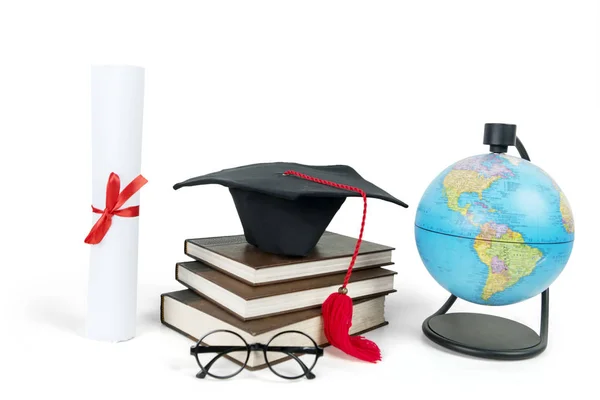 Graduation cap on a pile of books with globe — Stock Photo, Image